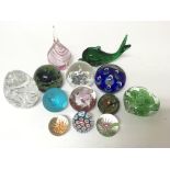 A collection of thirteen glass paperweights of var