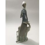 A Lladro figure of a girl with a deer at her side,