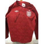 A child's red England football shirt signed by Way