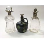 A silver topped glass decanter, a silver topped Royal Doulton decanted and a silver plate topped