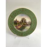 A fine quality Royal Worcester plate, the green ground painted with a garden landscape