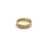 A 22ct gold ring with repeated etched decoration,