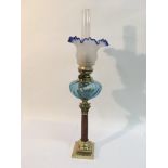 An oil lamp with blue and clear glass shade plus a