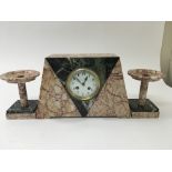 An Art Deco marble mantel clock with garnitures.