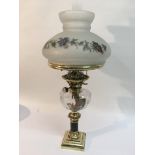 A brass oil lamp with a floral decorated frosted g