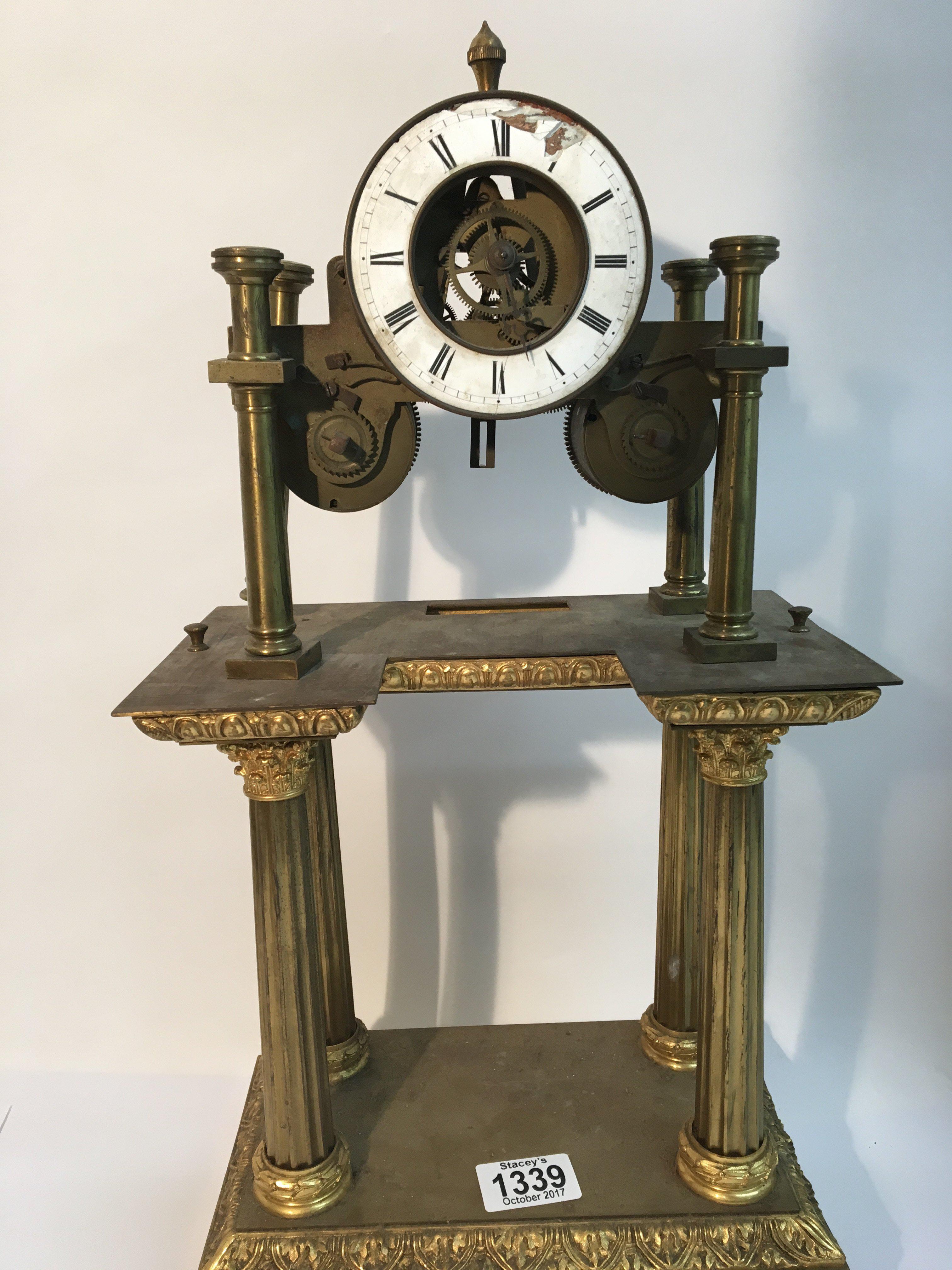 A French brass clock with four pillars and enamel