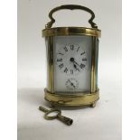 An oval brass carriage clock.