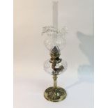 A brass oil lamp with clear glass shade, the base