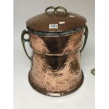 A hand hammered copper and brass coal bin with cov