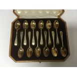 A set of twelve silver gilt tea spoons fitted in a Harrods case London hallmarks