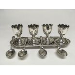 A silver egg cup set comprising four cups on stand with a of four spoons Birmingham hallmarks