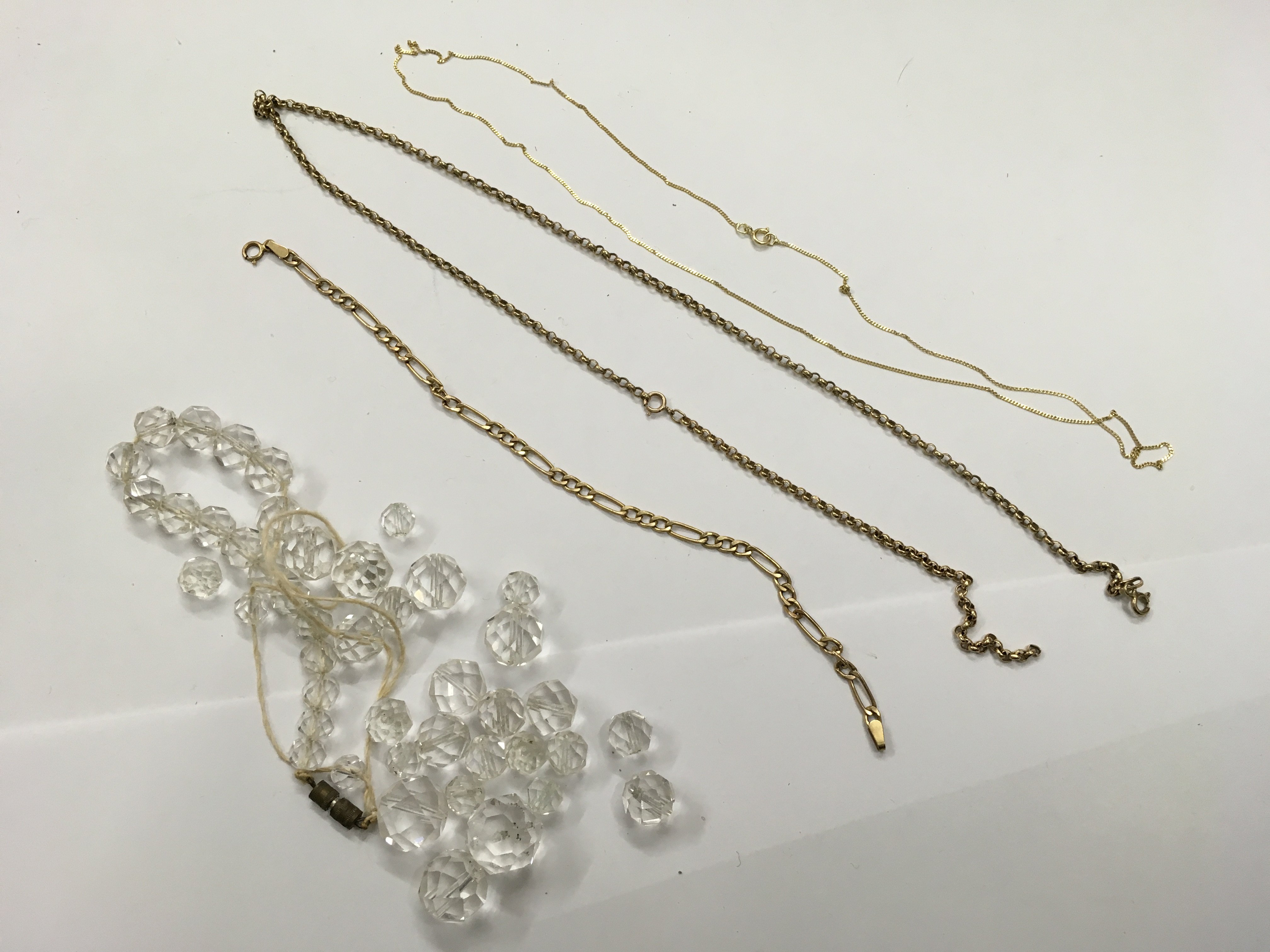 2 gold necklaces, a gold bracelet and a cut glass bead necklace in need of restringing.
