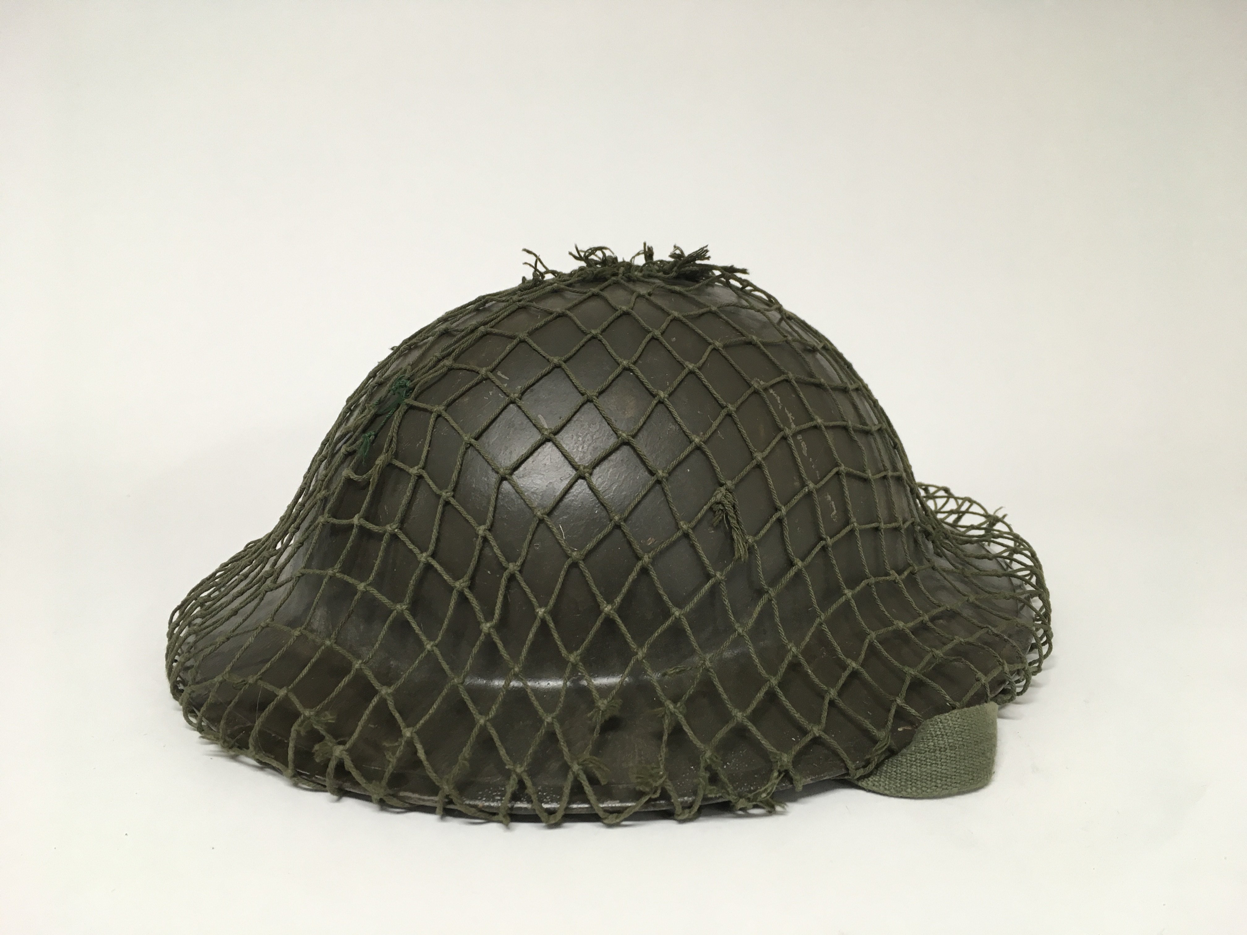 A British WW2 "Brodie" helmet with a quick release chin strap, original helmet liner and