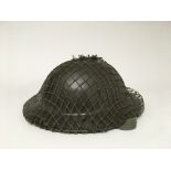 A British WW2 "Brodie" helmet with a quick release chin strap, original helmet liner and