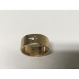 A 9ct gold band ring inset with small diamond