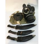 Three Kuhkri knives and a WW2 gas mask.