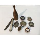 A collection of items including enamel badges, a m