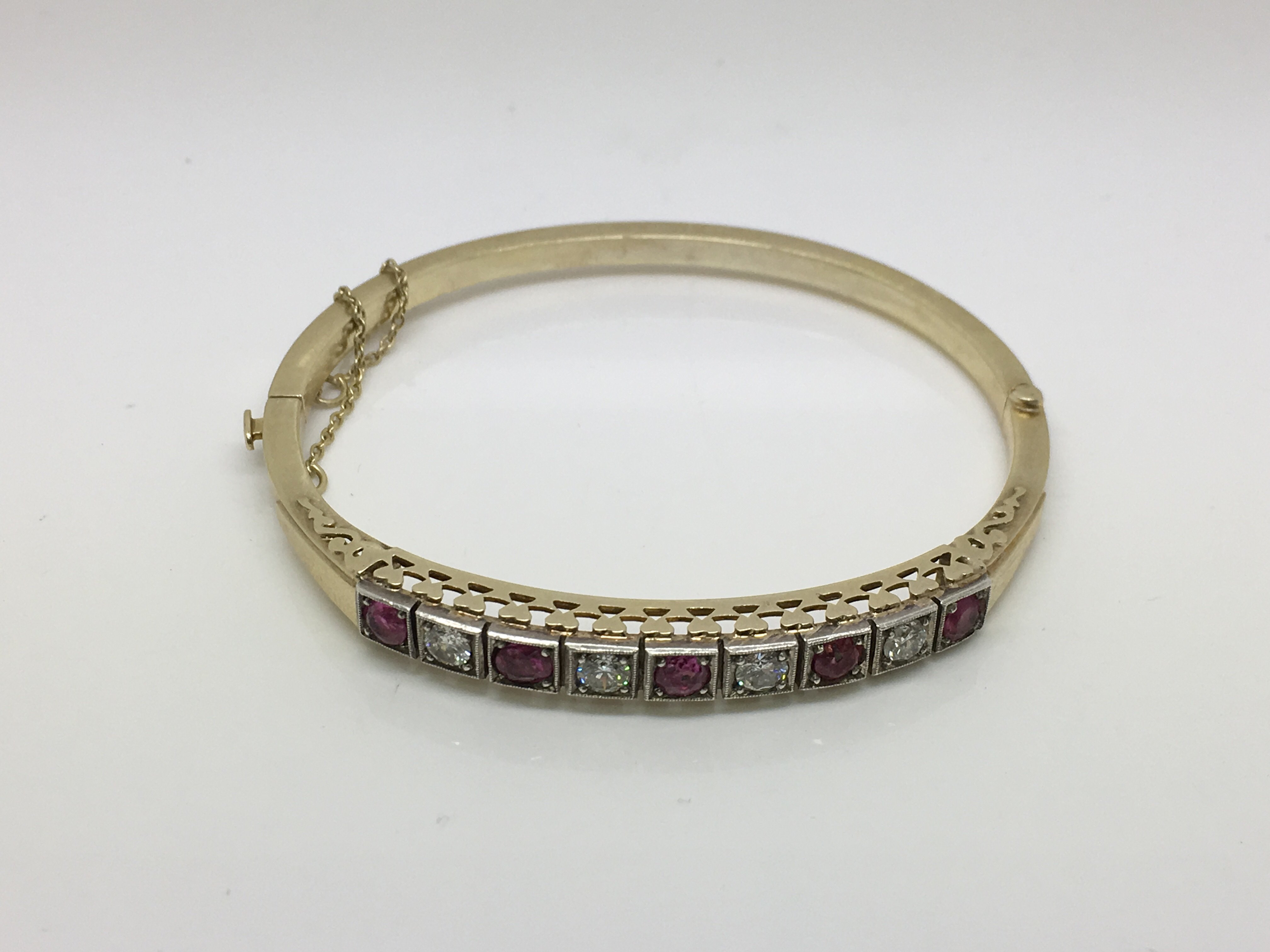 A boxed 14ct yellow gold bangle set with four diamonds and five rubies, approx 15.4g. - Bild 2 aus 3