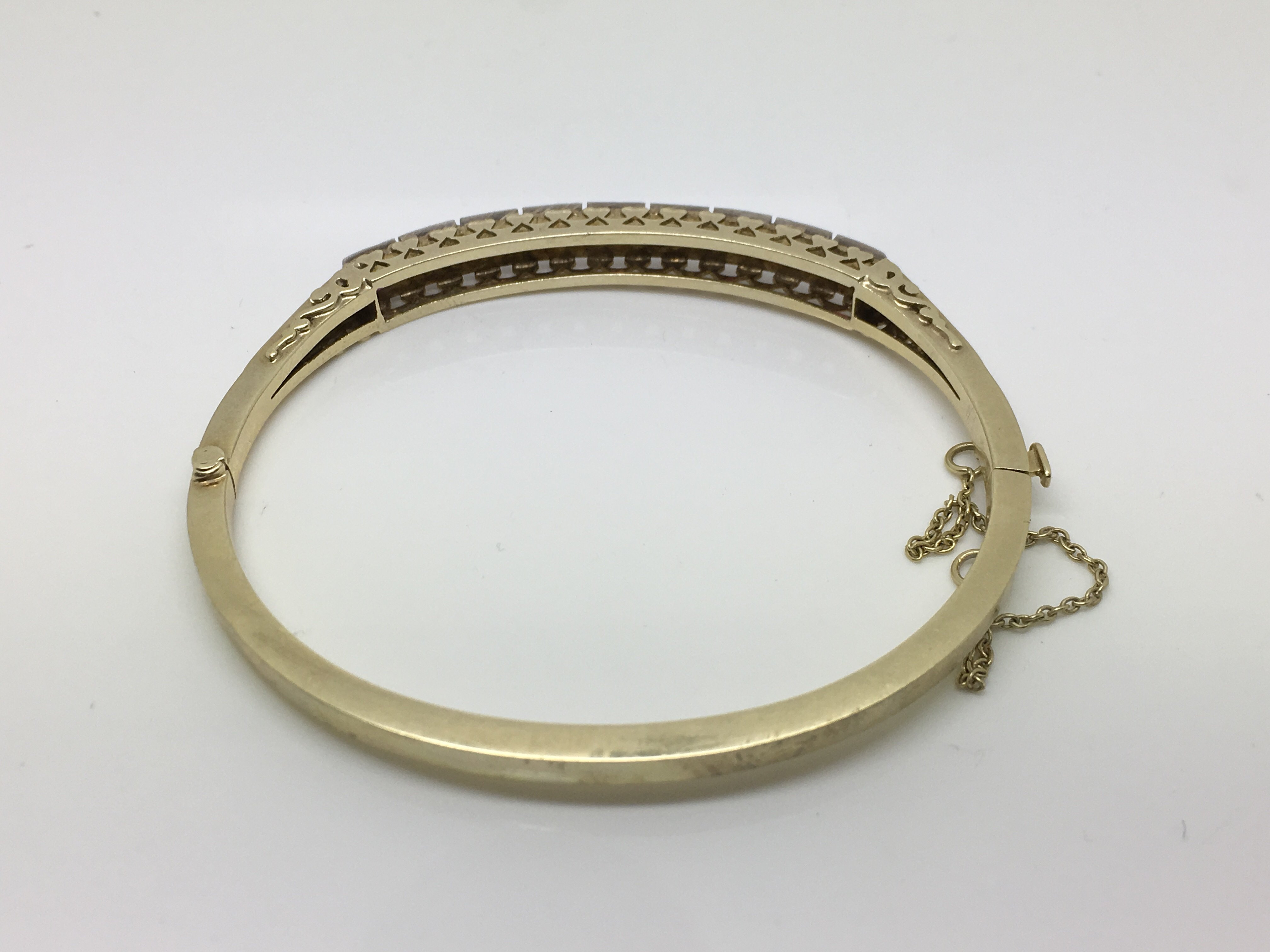 A boxed 14ct yellow gold bangle set with four diamonds and five rubies, approx 15.4g. - Bild 3 aus 3
