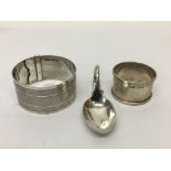 A silver bangle, napkin ring and spoon (3).