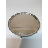 A silver tray with shaped edge on ball and claw fe
