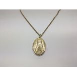 A 9ct gold oval locket with attached gold chain, w