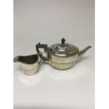 A silver teapot Sheffield hallmarks 1930 And a milk jug Sheffield hallmarks 1922 , 623 grams