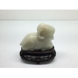 A small, carved white jade model of a seated ram o