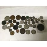 A large silver coin along with a collection of various other coins.