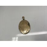 An oval 9ct gold locket. Weight approx 9.15g