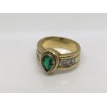 A six diamond ring inset with a central teardrop shaped green stone, approx size K and 10g.