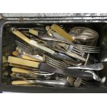 A tin containing a large volume of various cutlery together with a vintage money tin containing