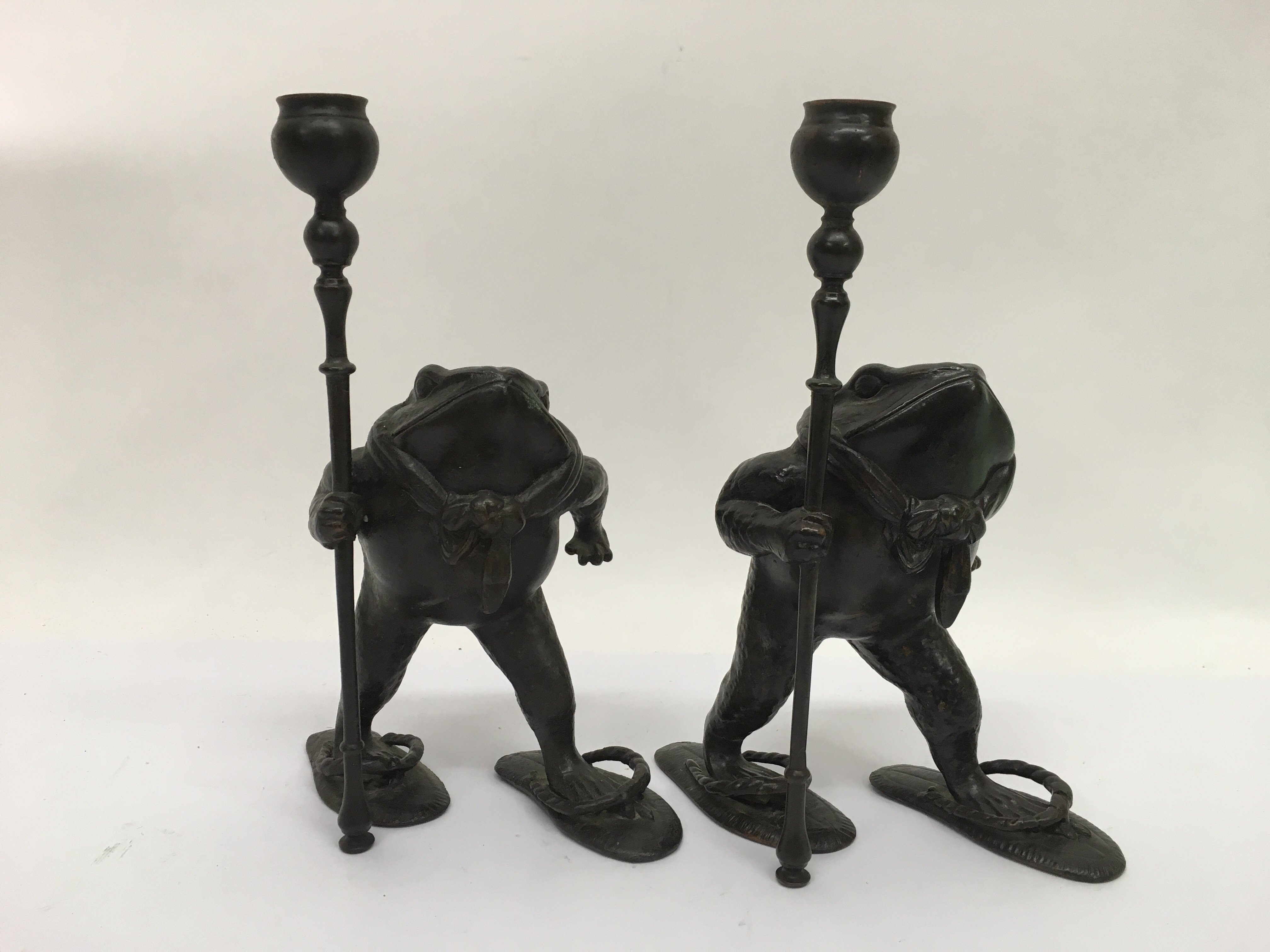 A pair of bronze candlesticks in the form of anthr