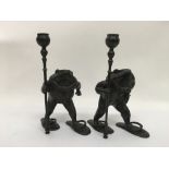 A pair of bronze candlesticks in the form of anthr