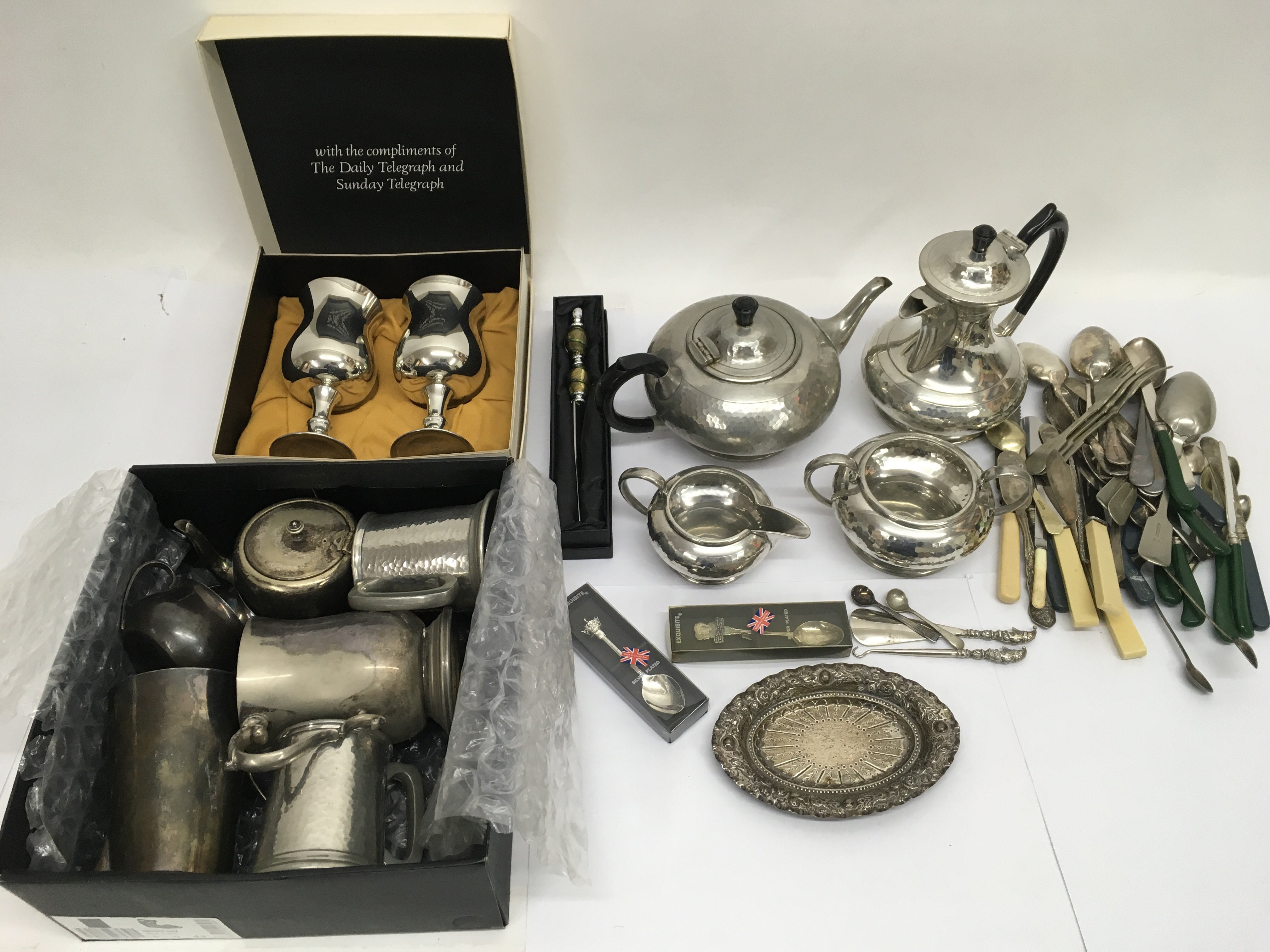A collection of metalware including a pewter four piece tea and coffee service, various cutlery,