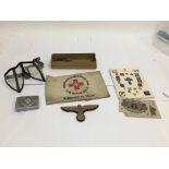 A small grouping of items including goggles, bank notes, an armband and lanyard.