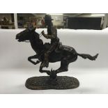A Frederic Remington bronzed figure of a cowboy on