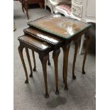 A burr walnut nest of three tables raised on cabri