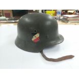 A WW2 German helmet bearing an Italian insignia on