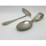 A white metal spoon and pusher, possibly Oriental