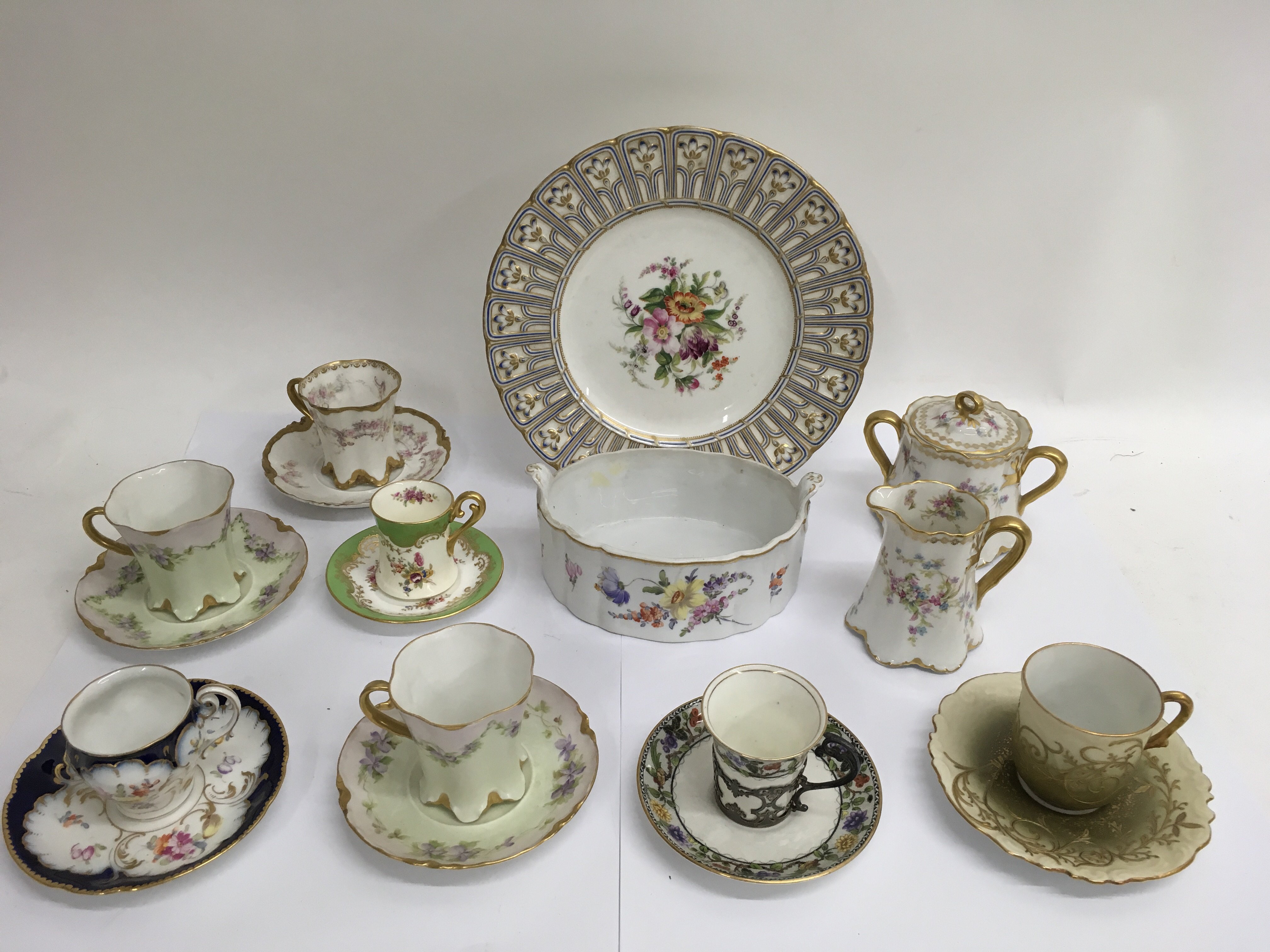 A group of decorative cups and saucers including L