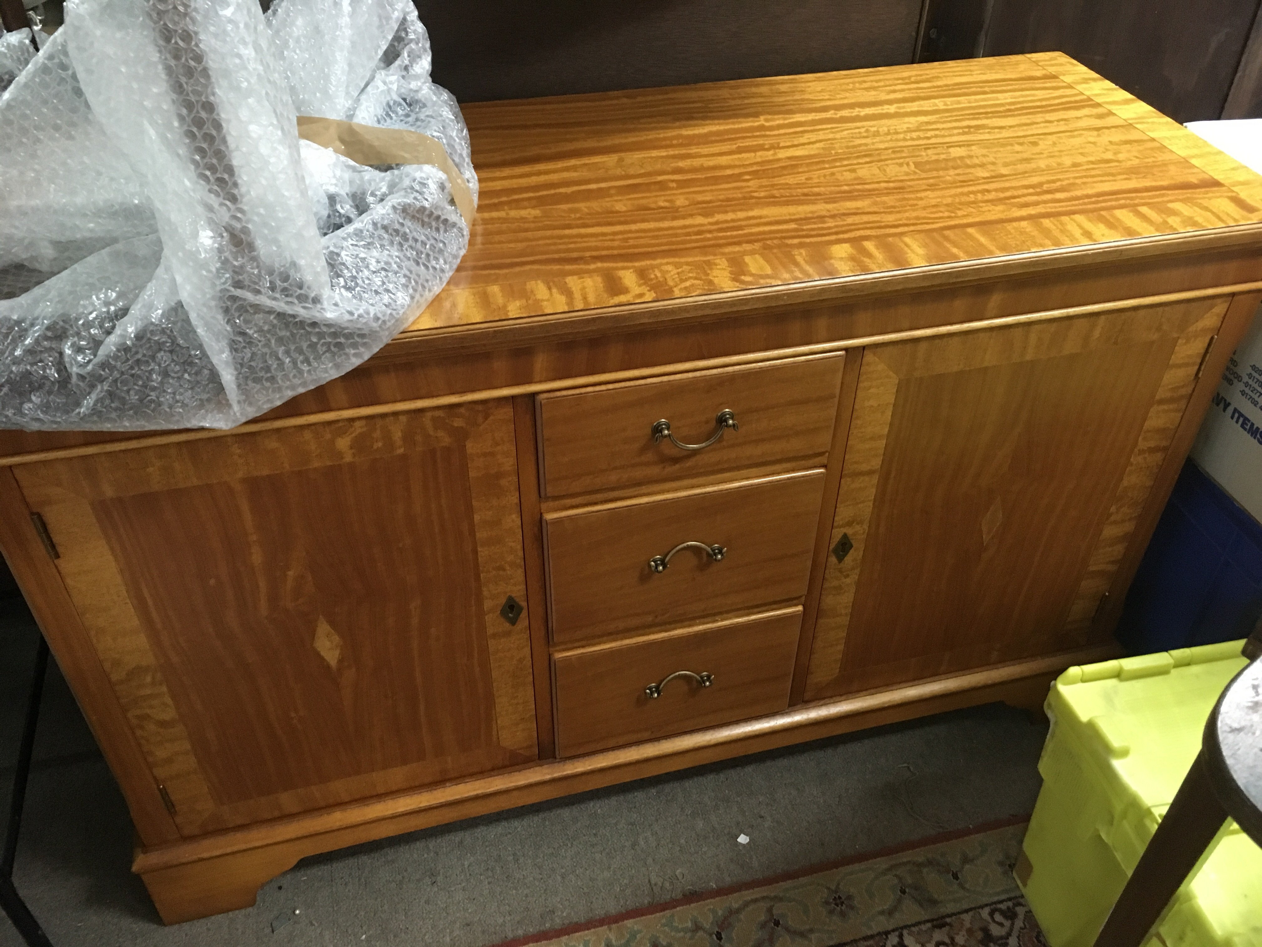 A satin wood sideboard with another small table.