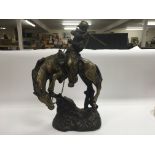 A bronzed Frederic Remington figure of a cowboy on