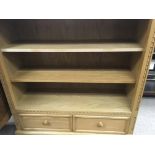 A oak open bookcase with a single drawer