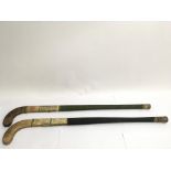 Two old hockey sticks, one bearing names of the 19