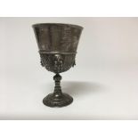 A silver chalice with scrolled decoration and lion