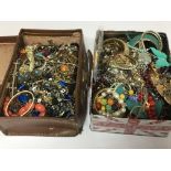 A small case and a tin of costume jewellery.