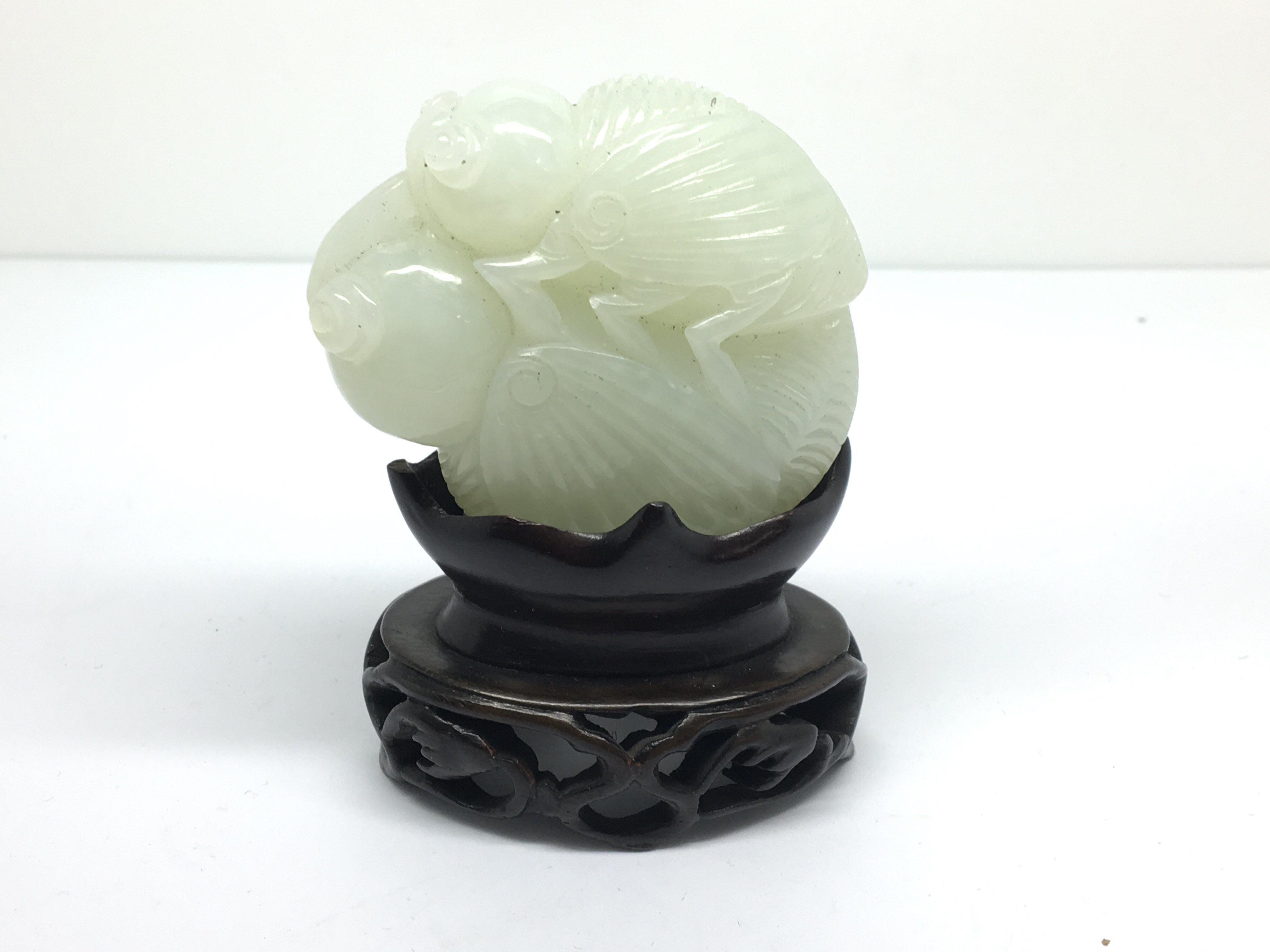 A small carved, light green jade model of a grassh