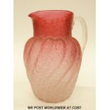 A late 19thC Stourbridge cranberry glass jug of twisted form with crackle finish, 21cm tall.
