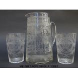 A clear glass jug and two matching beakers, all with elaborate engraved decoration, jug 18cm tall.
